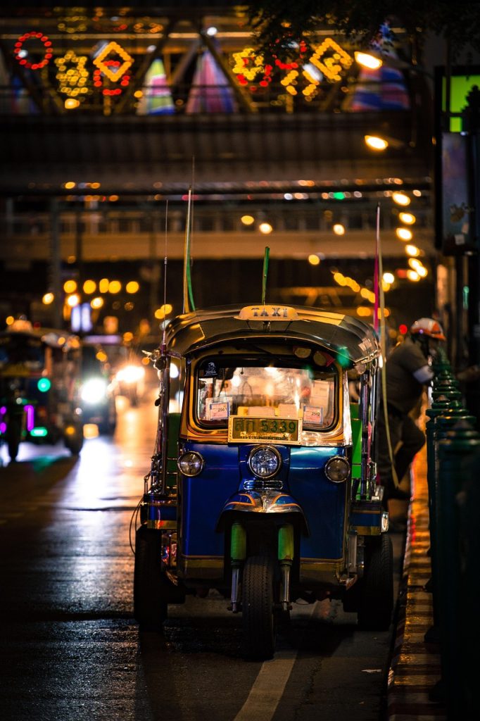 Tuk-tuk taxi on a busy Bangkok street at night